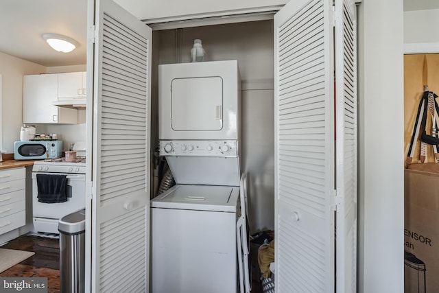 clothes washing area featuring stacked washer and clothes dryer