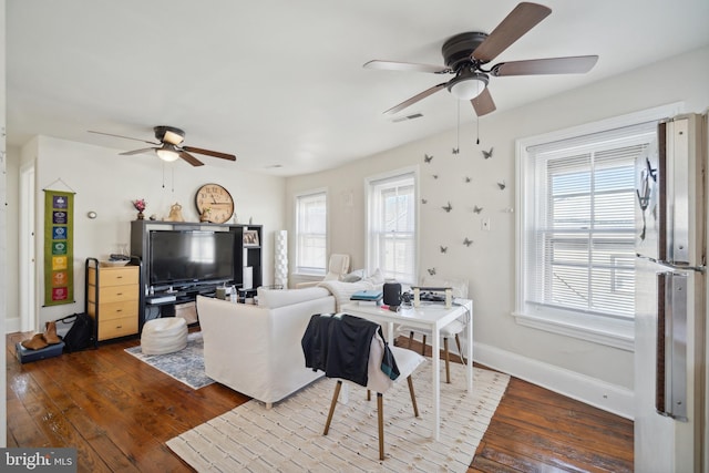 living room featuring a wealth of natural light, dark wood-type flooring, and ceiling fan