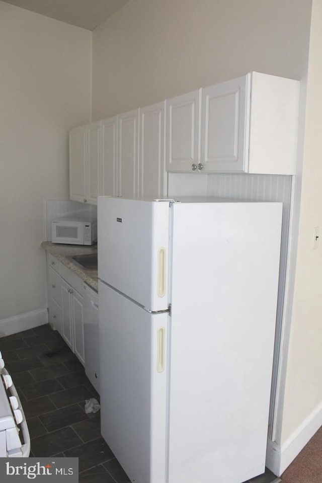 kitchen with sink, white appliances, and white cabinets