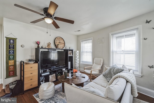 living room with ceiling fan, dark wood-type flooring, and a healthy amount of sunlight