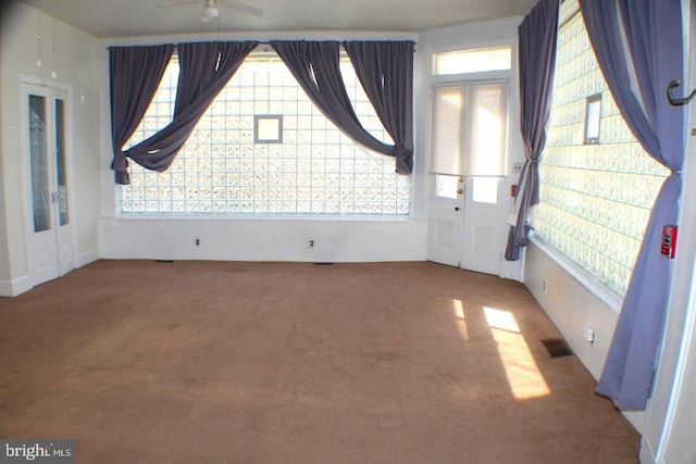 unfurnished room with ceiling fan, a healthy amount of sunlight, and carpet floors