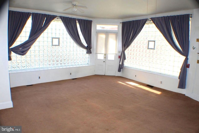 empty room featuring ceiling fan and carpet