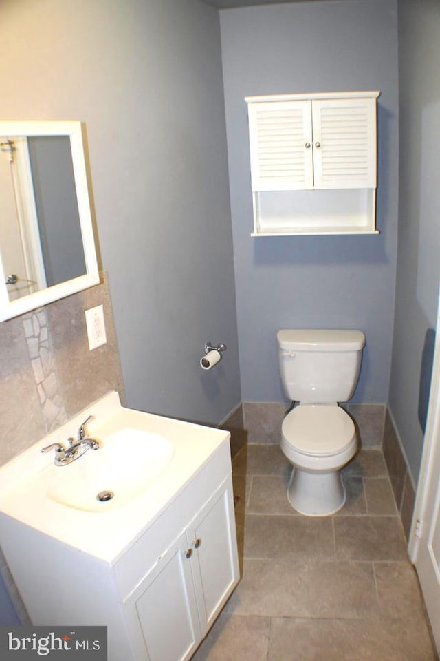 bathroom with tile patterned flooring, vanity, and toilet