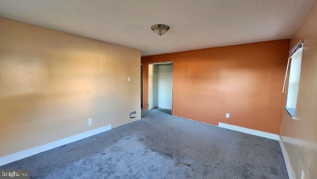 unfurnished room featuring dark carpet