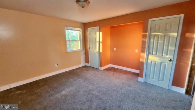 unfurnished bedroom with dark colored carpet