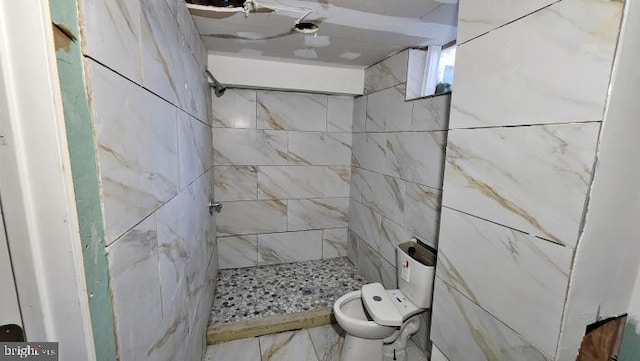 bathroom with tiled shower and toilet