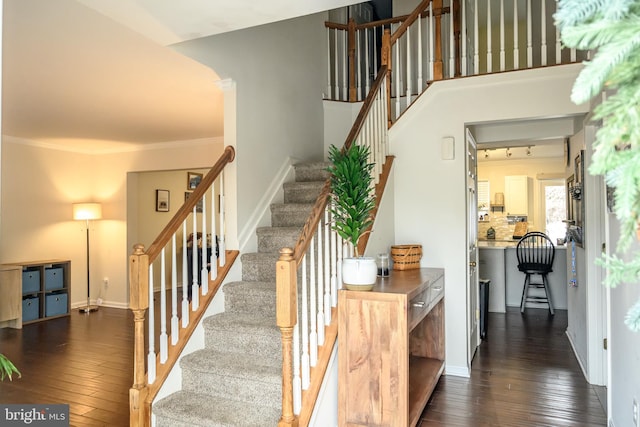 stairway featuring ornamental molding and wood-type flooring