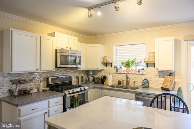 kitchen with appliances with stainless steel finishes, sink, decorative backsplash, and white cabinets