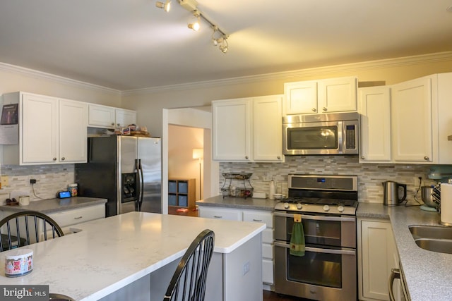 kitchen with tasteful backsplash, stainless steel appliances, white cabinets, and a kitchen island