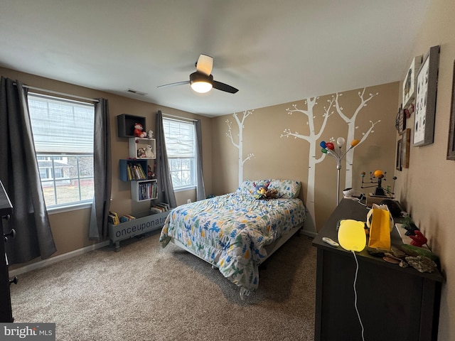 carpeted bedroom with multiple windows and ceiling fan