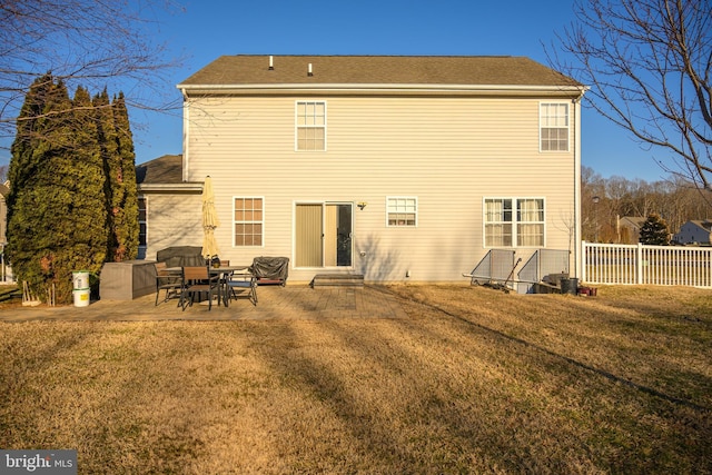 rear view of property with a patio and a lawn