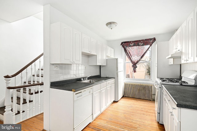 kitchen featuring sink, white cabinetry, radiator, white appliances, and light hardwood / wood-style floors