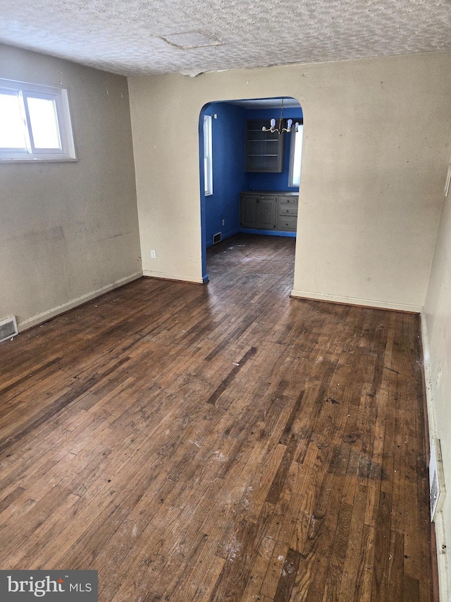 empty room featuring dark hardwood / wood-style flooring and a textured ceiling