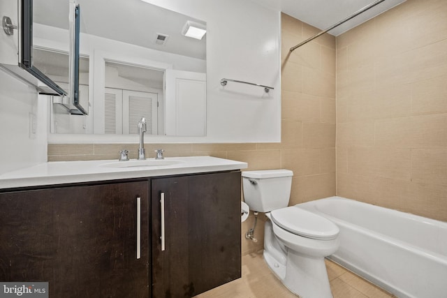 full bathroom with tiled shower / bath combo, vanity, tile walls, and toilet