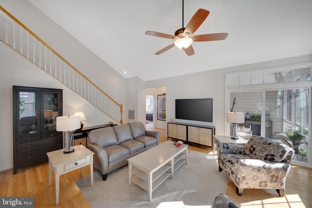 living room with ceiling fan, a wealth of natural light, and light wood-type flooring