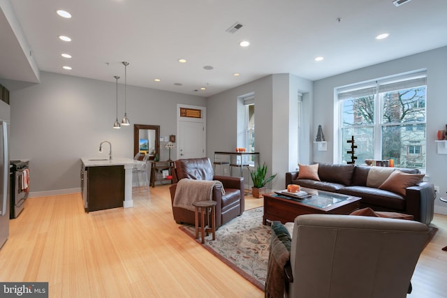 living room with sink and light hardwood / wood-style floors