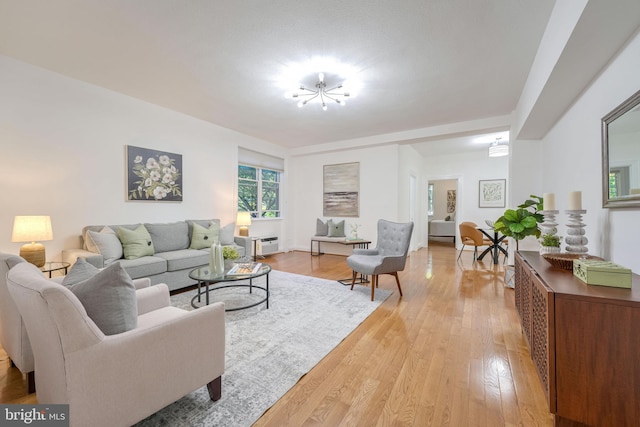 living room with an inviting chandelier and light hardwood / wood-style floors