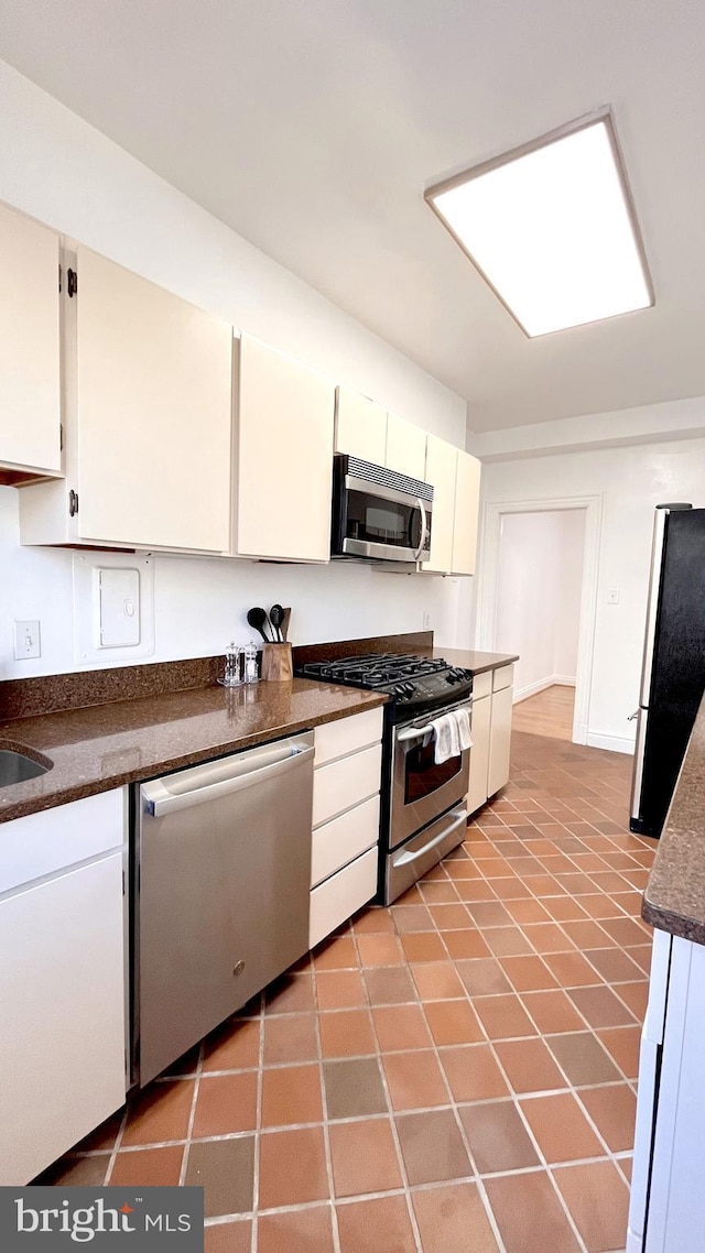 kitchen featuring white cabinetry, appliances with stainless steel finishes, and light tile patterned floors