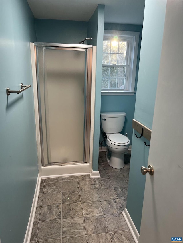 bathroom with an enclosed shower and toilet