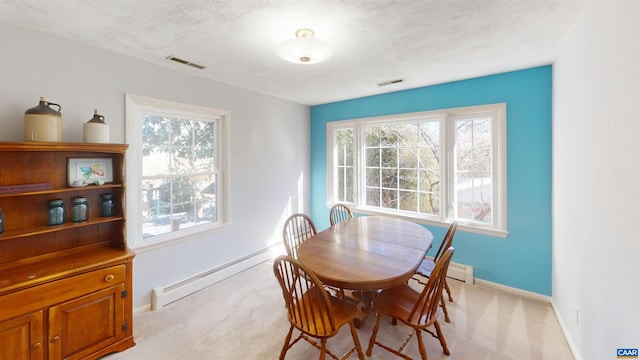 carpeted dining space with a textured ceiling and baseboard heating