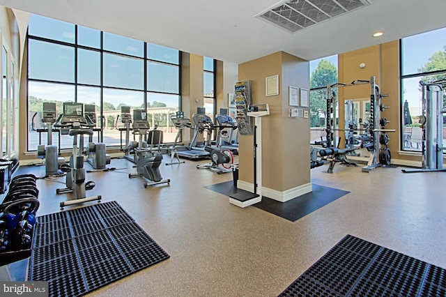 exercise room featuring baseboards, visible vents, and expansive windows