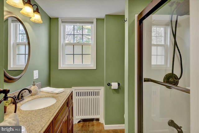 bathroom featuring radiator heating unit, vanity, and plenty of natural light