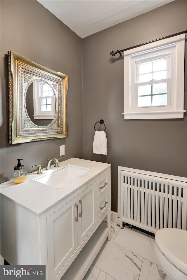 bathroom with vanity, radiator, and toilet