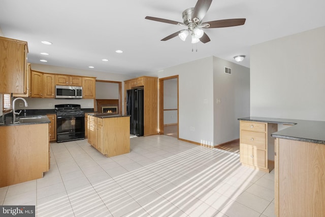 kitchen with sink, a center island, light tile patterned floors, ceiling fan, and black appliances