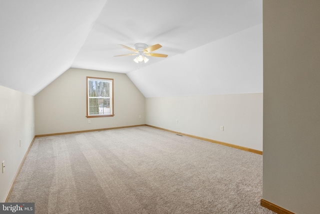 additional living space with ceiling fan, vaulted ceiling, and light carpet