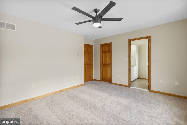 unfurnished bedroom featuring ceiling fan, ensuite bath, and light colored carpet