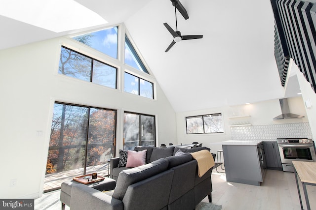 living room featuring high vaulted ceiling, ceiling fan, and light hardwood / wood-style flooring