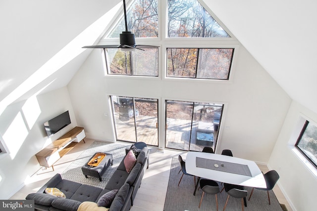 living room featuring a high ceiling, a healthy amount of sunlight, and ceiling fan