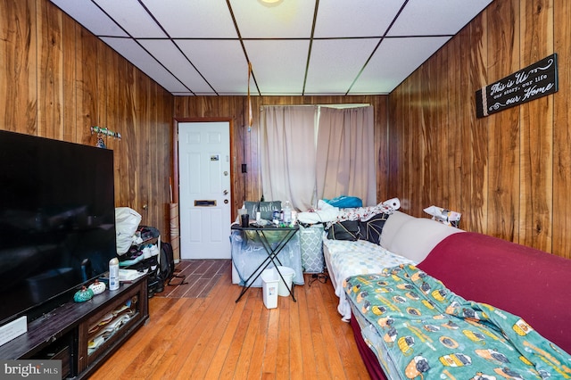 bedroom with wood-type flooring and wooden walls