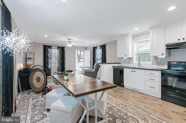 kitchen with crown molding, black appliances, white cabinets, and light wood-type flooring