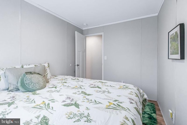 bedroom with crown molding and hardwood / wood-style flooring