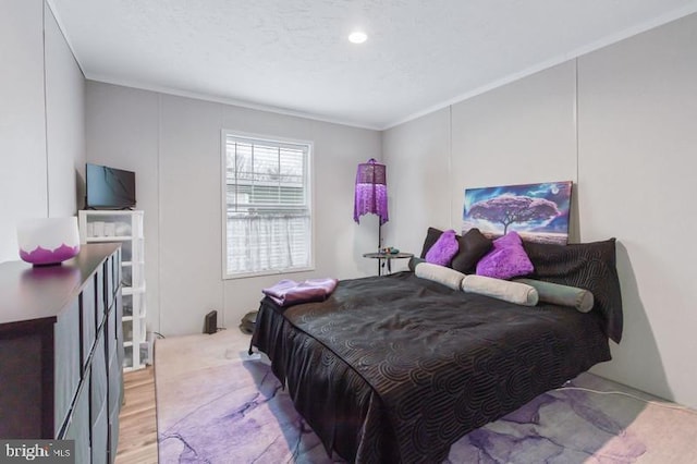 bedroom with ornamental molding and light hardwood / wood-style flooring