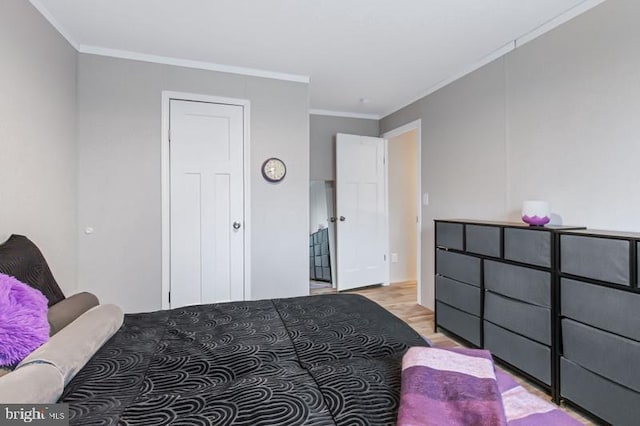 bedroom with crown molding and light wood-type flooring