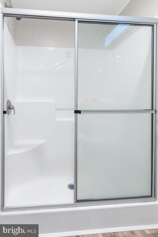 bathroom featuring walk in shower and hardwood / wood-style flooring