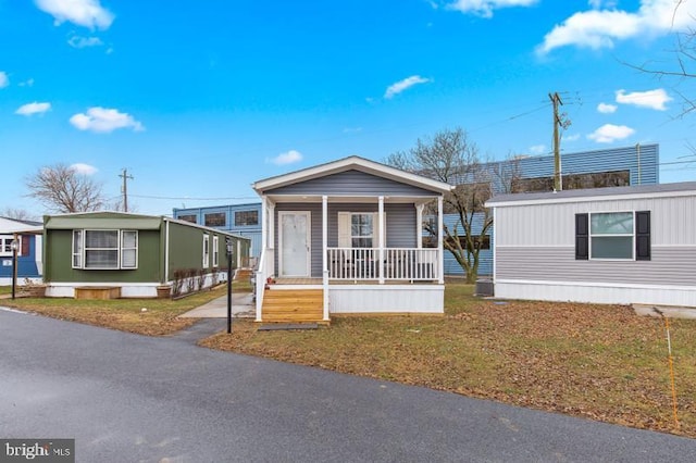 manufactured / mobile home with a front yard and covered porch