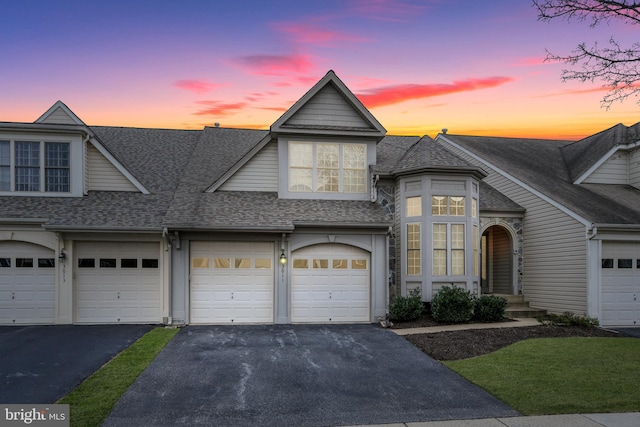 view of front of property with a garage, driveway, and a shingled roof