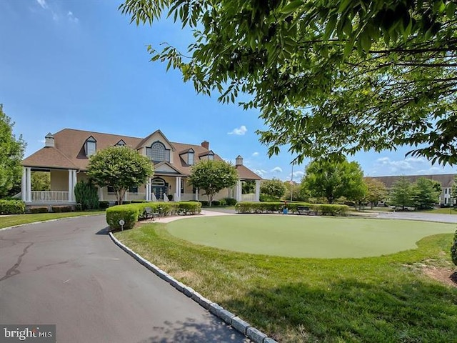 cape cod house featuring driveway and a front yard