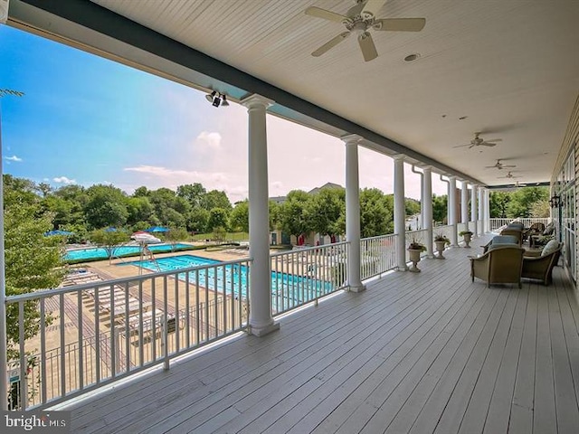 deck featuring a ceiling fan and a community pool