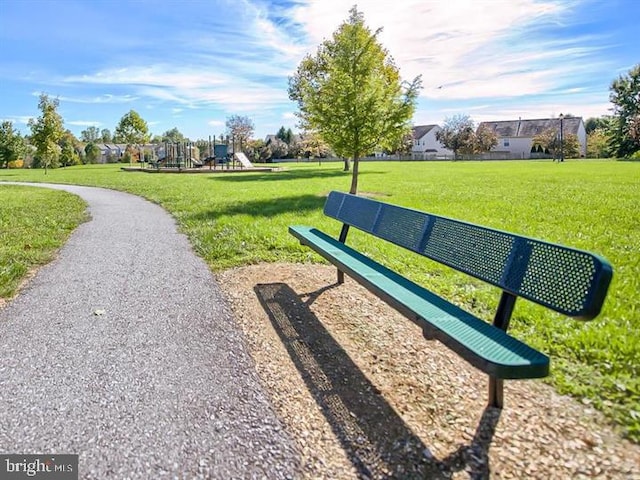 view of home's community with playground community and a lawn