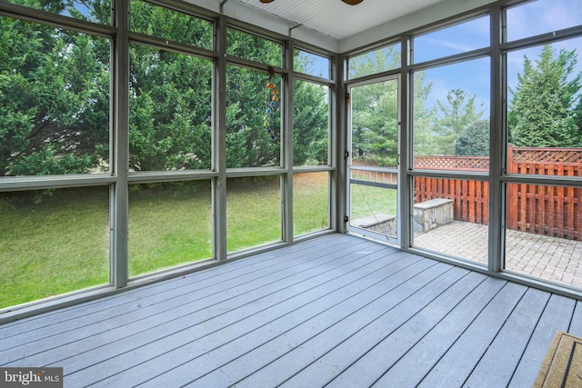 unfurnished sunroom featuring ceiling fan