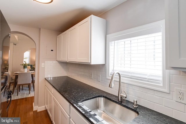 kitchen featuring dark stone counters, dark hardwood / wood-style floors, sink, and white cabinets