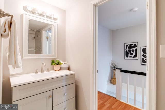 bathroom featuring hardwood / wood-style flooring, vanity, and a shower