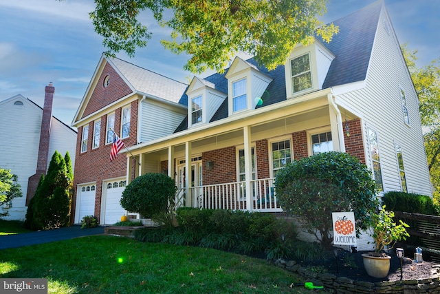 cape cod house with a garage, a porch, and a front lawn