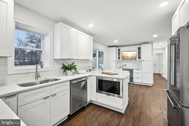 kitchen featuring a healthy amount of sunlight, stainless steel appliances, sink, and white cabinets