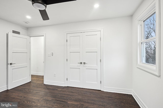 unfurnished bedroom featuring a closet, dark hardwood / wood-style floors, and ceiling fan