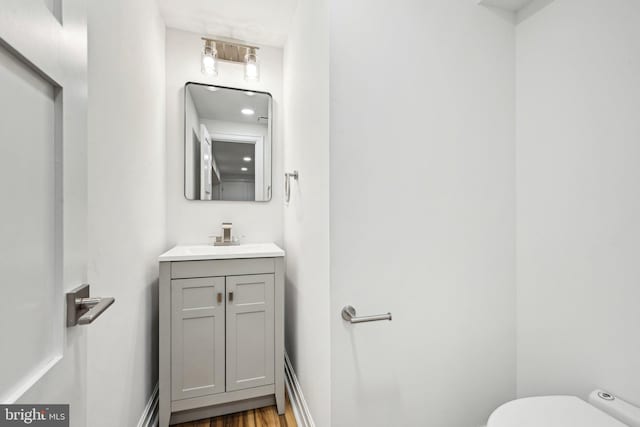 bathroom featuring hardwood / wood-style flooring, vanity, and toilet